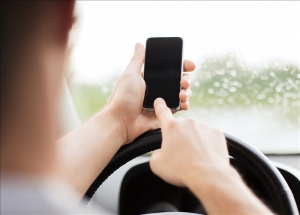 man using phone while driving the car